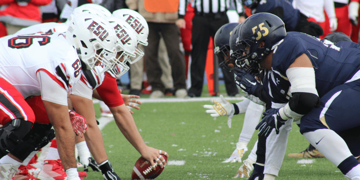 Football teams lined up at the line of scrimmage ready to play