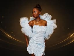 Couture model in sculptural blue dress featured in JCI’s fashion and visual storytelling exhibition.