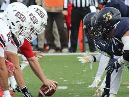 Football teams lined up at the line of scrimmage ready to play