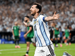 Football player celebrating a goal for Argentina in a packed stadium