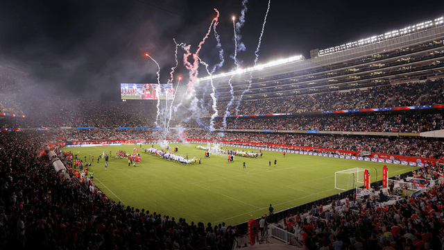 Crowd in stadium celebrating a sports event with fireworks and team presentations on the field