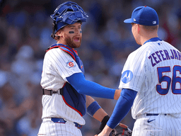 Two baseball players in team uniforms celebrating on the field during a game