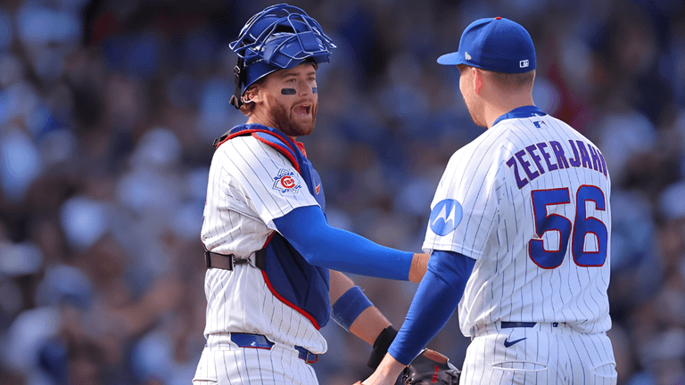 Two baseball players in team uniforms celebrating on the field during a game